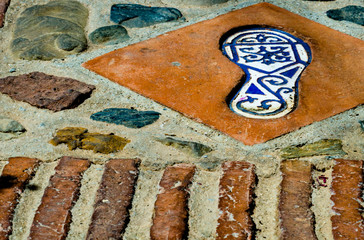 ceramic tile with an element of reflection of the human foot, a decorative element leading along the tourist trail in a historical Spanish town