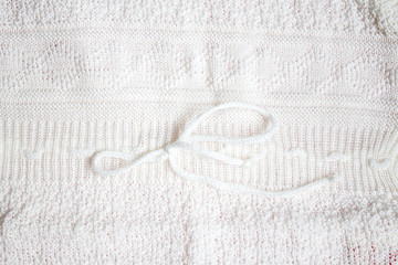 Texture of a White baby's knitted clothes