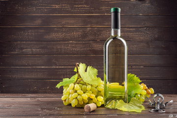 Wine bottle and grape on wooden table