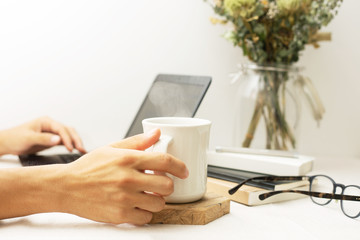 パソコン作業中にコーヒーを飲んで一服