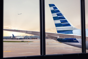 View of airplane fuselage tail through window at airport