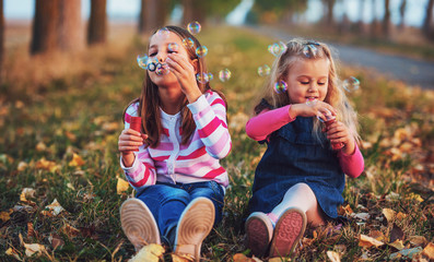 Childhood time. Cute little girls makes a soap bubbles © bobex73