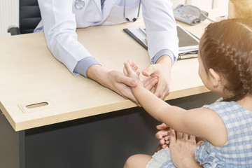 Fototapeta premium Pediatrician (doctor) man examining,reassuring and discussing kid in hospital room.Copy space.