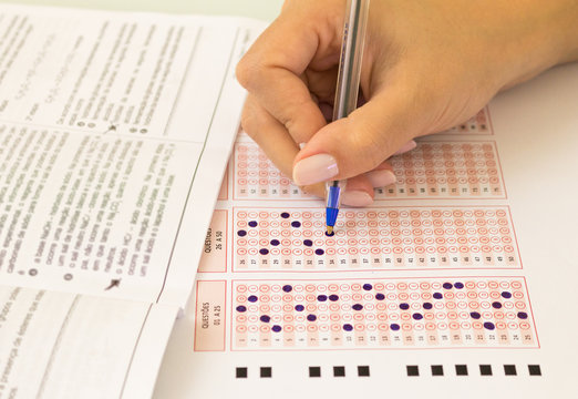 Education and concept. Student. Female hand with pen filling multiple choice test. Optical form of an examination.