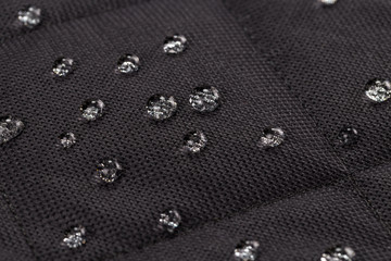 Water drops on waterproof black fabric