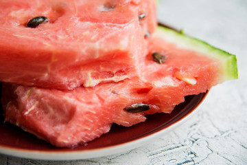 Slices of fresh ripe watermelon on a concrete background