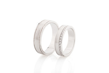Pair of silver wedding rings with diamonds isolated on white background