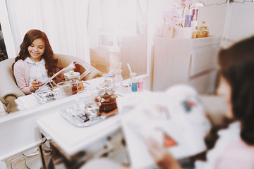 Beautiful Little Girl Reading Magazine in Salon.