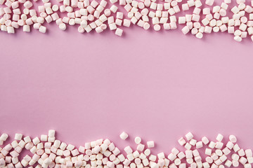 White and pink marshmallows on pink background, top view