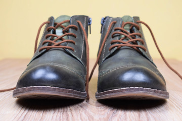 A pair of khaki color oxford man shoes on white wooden background. Fashion footwear. Brogues