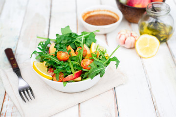 Fresh salad  arugula with tomatoes,apple  and mixed greens .