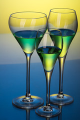 three glasses with cocktails on a blue table 