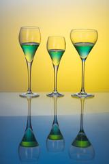 three glasses with cocktails on a blue table 