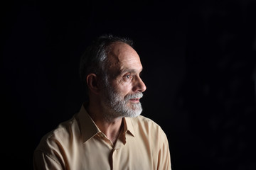 portrait of middle aged man on black