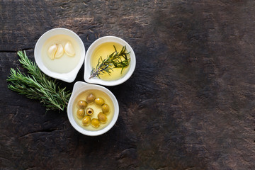 Rosemary,Olive oil with fresh herbs on wooden background copy space .