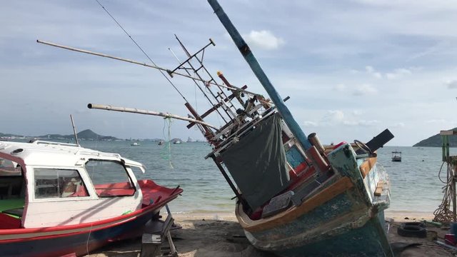 Fishing boats in the harbor. Shipwreck on the beach. An old wrecked wooden boat near the shore with the beach.
