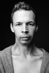 Obraz premium Rebellious man against black background in black and white