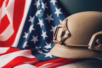 Military helmets and American flag on background