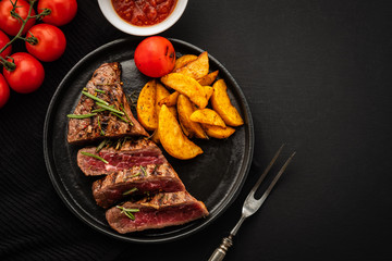 Delicious beef steak with salad, aromatic herbs, chery tomatoes and potatoes