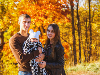 Fototapeta premium Smiling mother and father of a newborn baby . In autumn Park