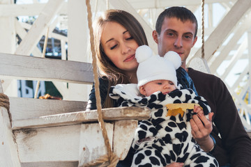 the happiest young parents with a little newborn daughter in the Park
