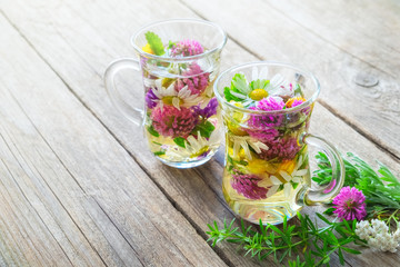 Two glass mugs of healthy herbal tea with medicinal herbs with copy space.