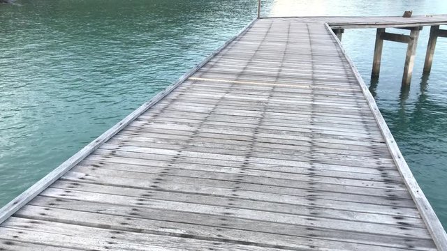 Old Wooden Bridge from beach to the sea.