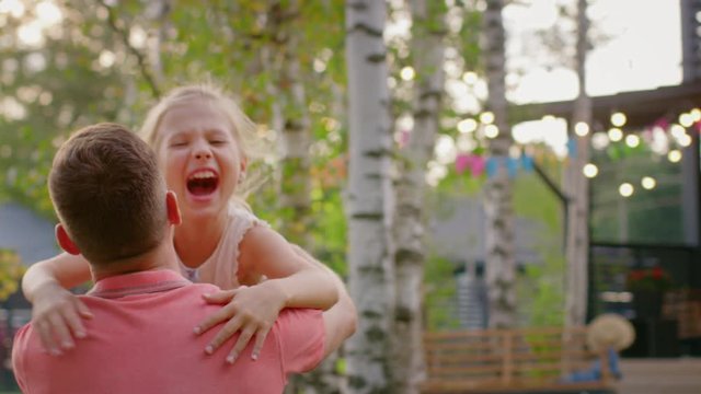 Cute Little Girl Runs Towards Father, He Stands on a Knee and Hugs Her
