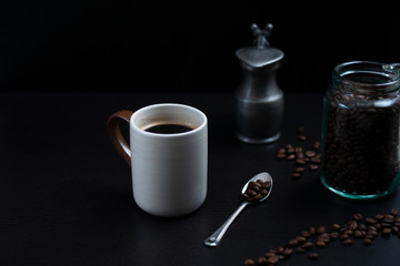 a cup of coffee and a jar of coffee beans