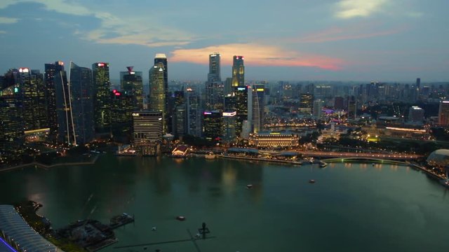 Panorama time lapse of Singapore Marina Bay with Financial District skyscrapers at sunset in the harbor. Singapore cityscape aerial view.