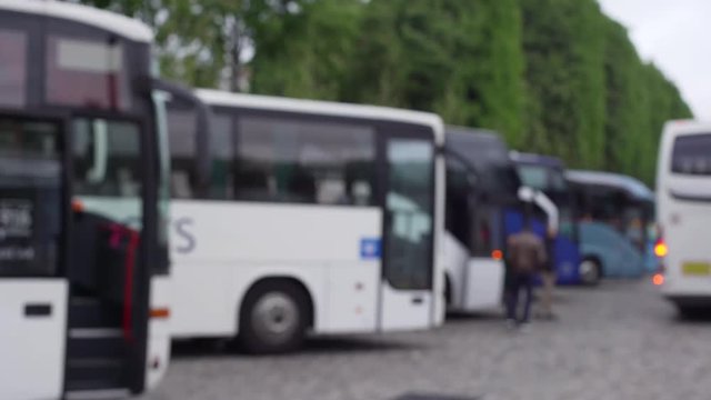 Blurred background plate of tour buses parked on a full lot