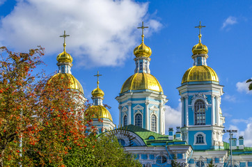 Fototapeta na wymiar St. Petersburg, autumn, red mountain ash and Golden domes of St. Nicholas Cathedral