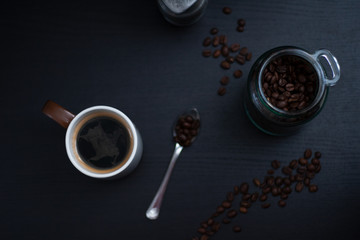 cup of coffee and beans on dark table