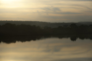 Fototapeta na wymiar Autumn landscape with the image of a lake at sunset