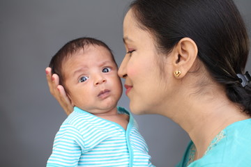 Cheerful mother playing with newborn baby
