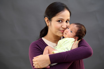 Cheerful mother playing with newborn baby - 227974178