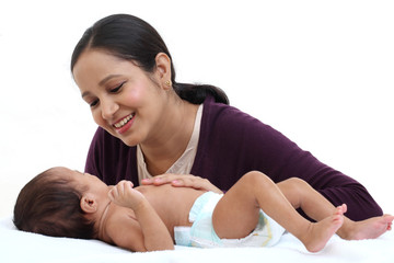 Cheerful mother playing with newborn baby