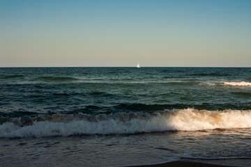Fototapeta premium Sailing yacht with white sails in the open Sea.