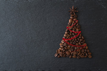 Christmas tree lined from coffee beans on a dark background