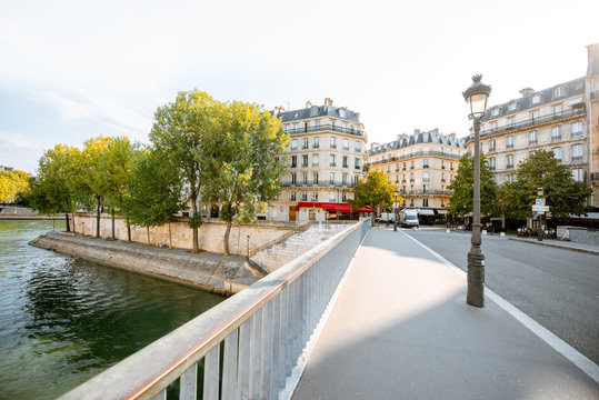 Street view with beautiful buildings and cafe terrace during the morning light in Paris