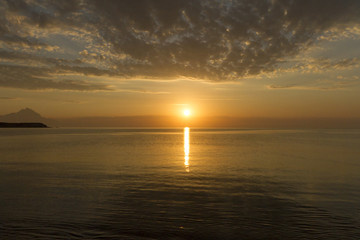 Silhouette of mount Athos at sunrise or sunset with light rays and sea panorama in Greece