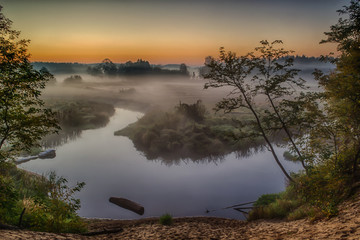 Rzeka Grabia w centralnej Polsce zaraz po wschodzie słońca otulona poranna mgłą - obrazy, fototapety, plakaty