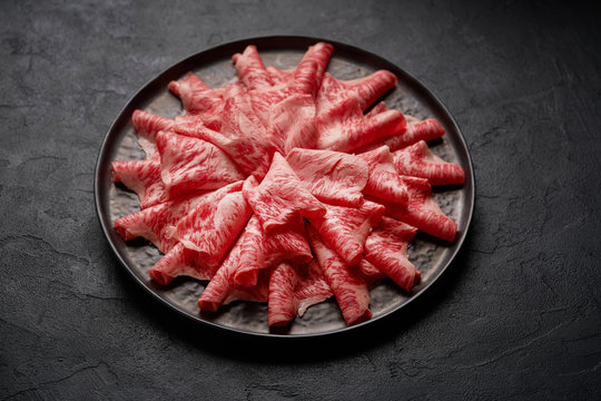 Japanese kobe beef sliced on plate prepared for shabu shabu on black background