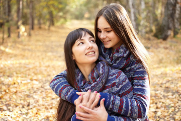 Fototapeta premium Cute portrait of mother and daughter in the autumn forest.
