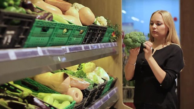 girl chooses vegetables and fruits in the supermarket