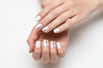 Crédence de cuisine en verre imprimé ManIcure manucure blanche délicate avec des rayures noires-rouges sur des ongles courts carrés sur un gros plan de fond blanc