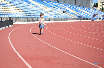 Obraz premium Little boy on the treadmill at the stadium.