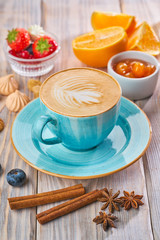Blue coffee cup with cappuccino, cinnamon and anise. Breakfast concept