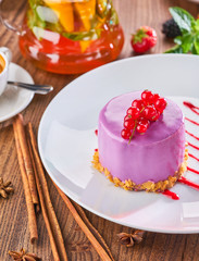 Mousse cake with red currants on white plate