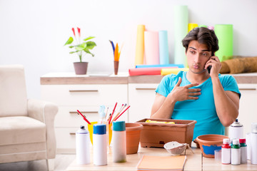 Young man decorating pottery in class